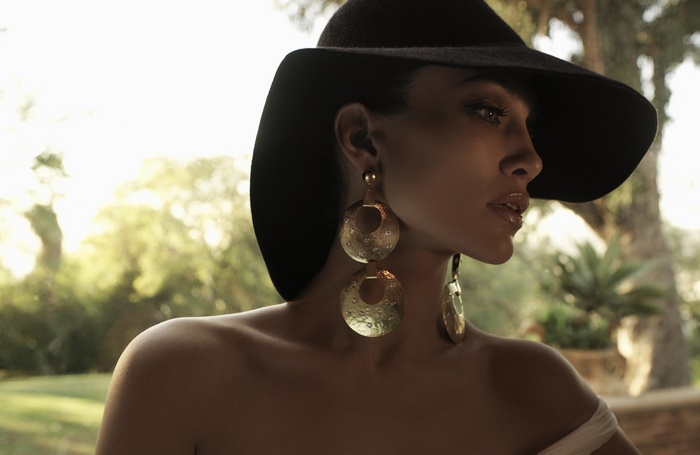 Jennifer Lopez wearing a black hat and large earrings
