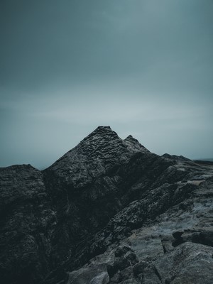 Dark, rocky mountain peaks under a cloudy sky