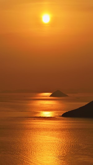 Sunset over the sea with islands and reflections
