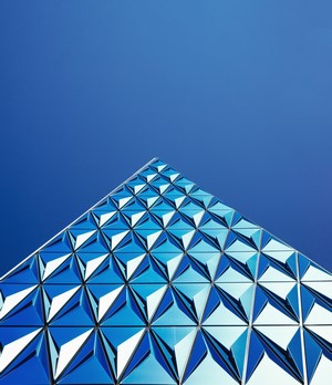 Modern building with geometric facade against clear blue sky