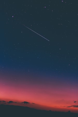 Shooting star in a twilight sky over a horizon