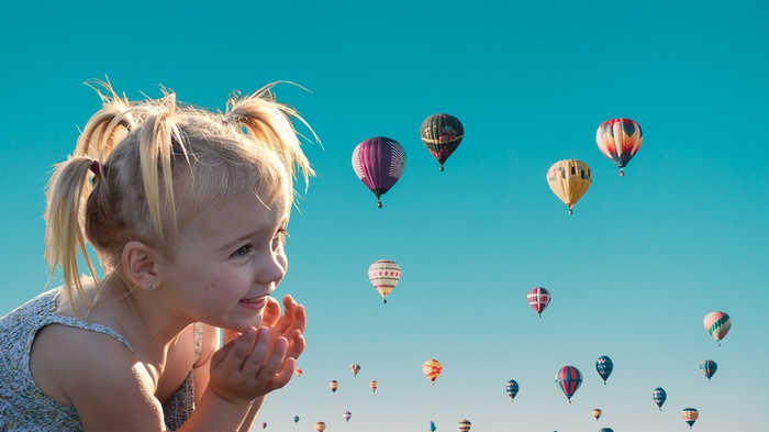 Cute girl watching hot air balloons