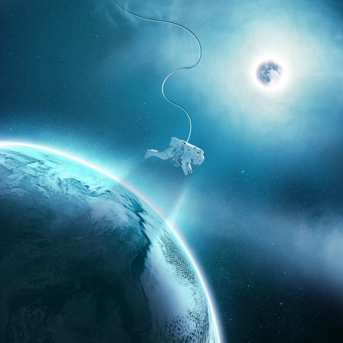 Astronaut floating in space near Earth and Moon