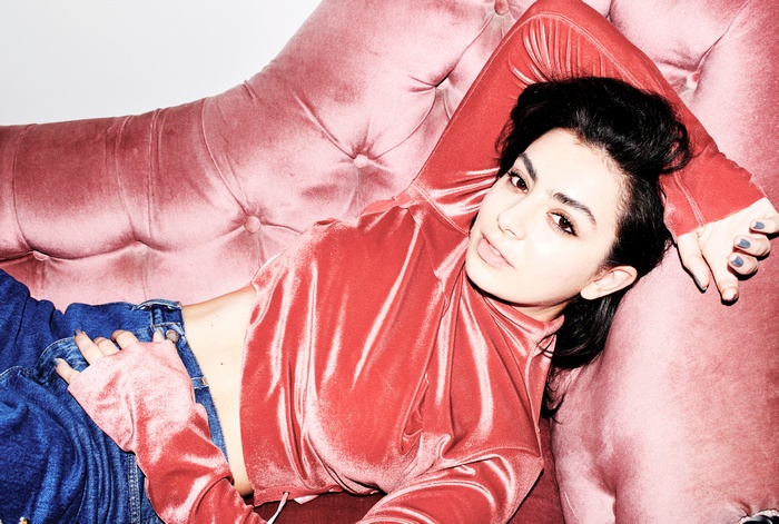 Charli XCX on a pink couch