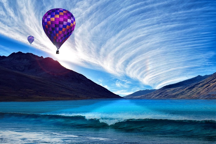Hot air balloons over mountains and sea at sunset 4K