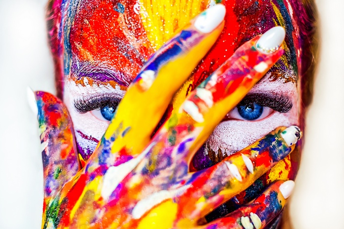 Woman with colorful paint on face and hand