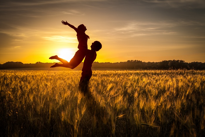 Couple Silhouetted in Wheat Field at Sunset