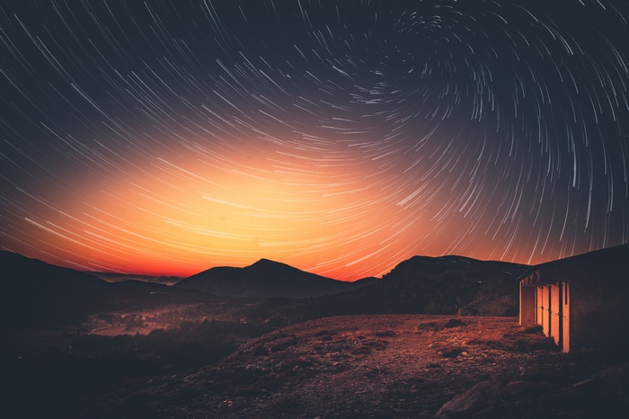 Star trails over mountains at dusk