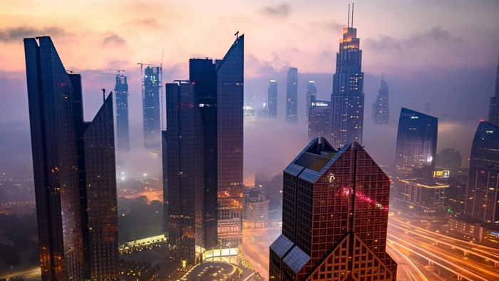 Aerial view of skyscrapers at dusk with fog