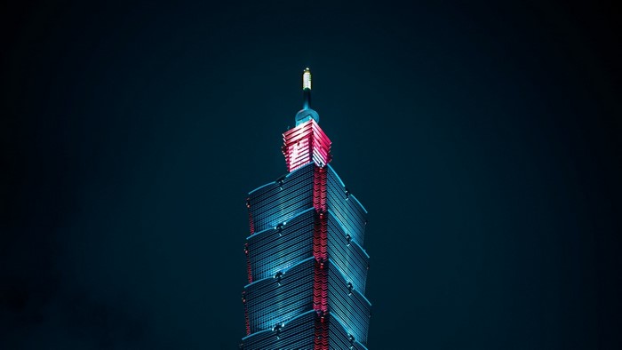 Skyscraper at night with blue and red lights