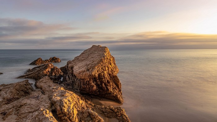 Rocks on a beach at sunset