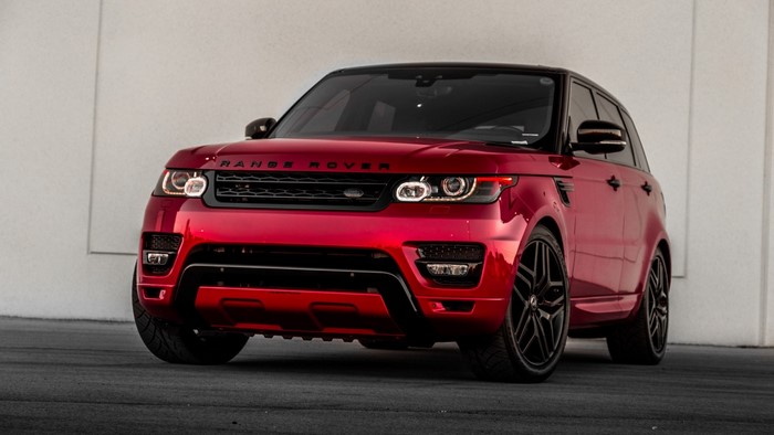 Red Range Rover Sport parked by a wall