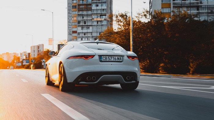 White Jaguar F-Type driving on a city street