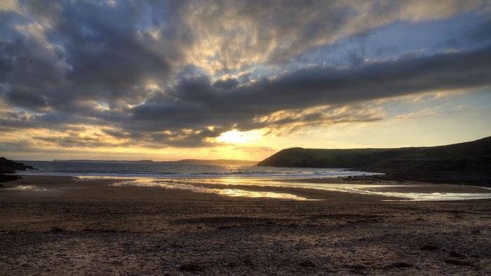 Sunset over a beach with dramatic clouds