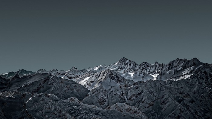 Snow-capped mountain range under a dark sky