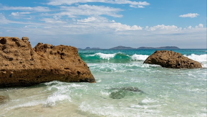 Rocky shore with waves and distant islands