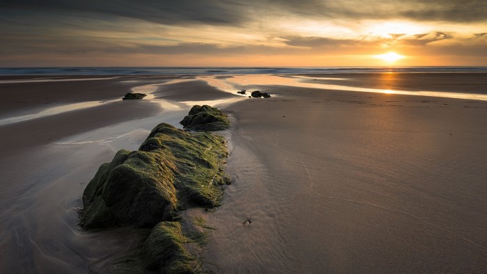 Sunset over a rocky beach with tide pools