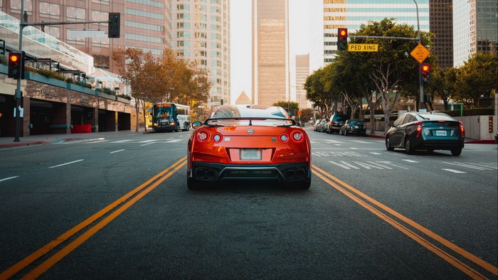 Orange Nissan GT-R driving on a city street