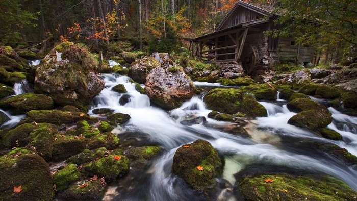 Old mill by a stream with mossy rocks