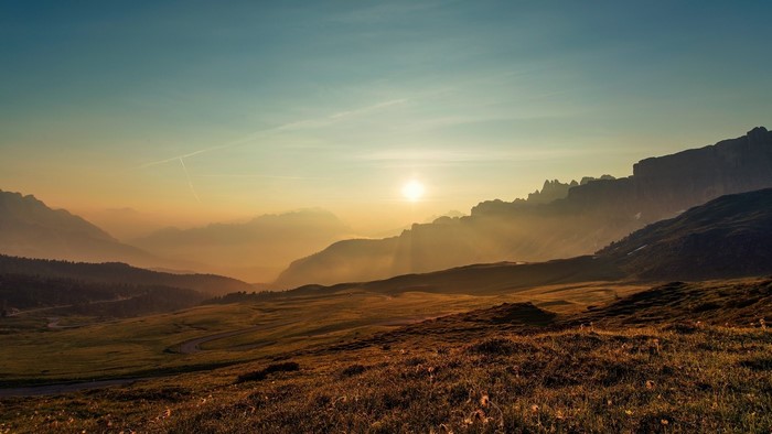 Mountain valley at sunset with sun rays