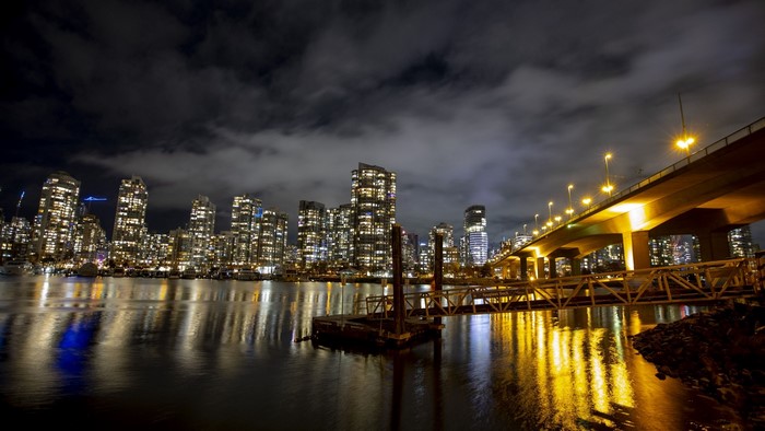 Night cityscape with illuminated buildings and bridge over water