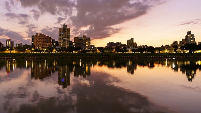 City skyline reflected in a lake at sunset