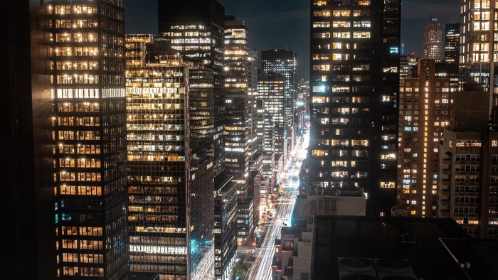 Nighttime cityscape with illuminated skyscrapers and street lights