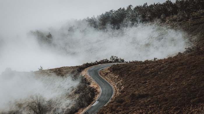 Winding road through a foggy mountain landscape