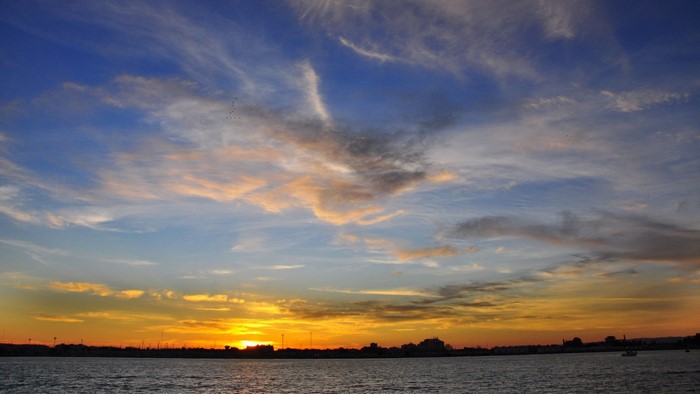 Sunset over the water with clouds