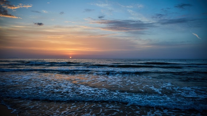 Sunset over the ocean with waves