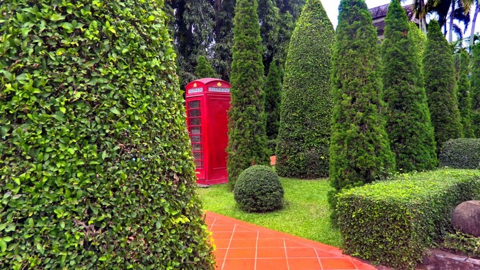 Red telephone box in a garden at Nong Nooch Tropical Garden