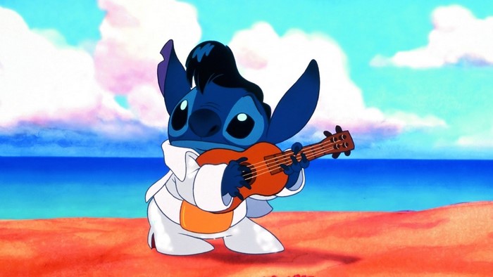 Stitch playing ukulele on a beach