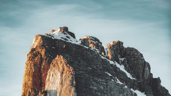 Rocky mountain peak with snow at sunset