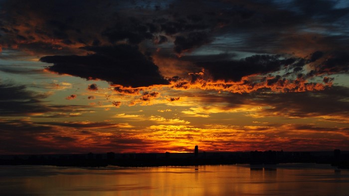 4K Sunset Over Water with City Silhouette
