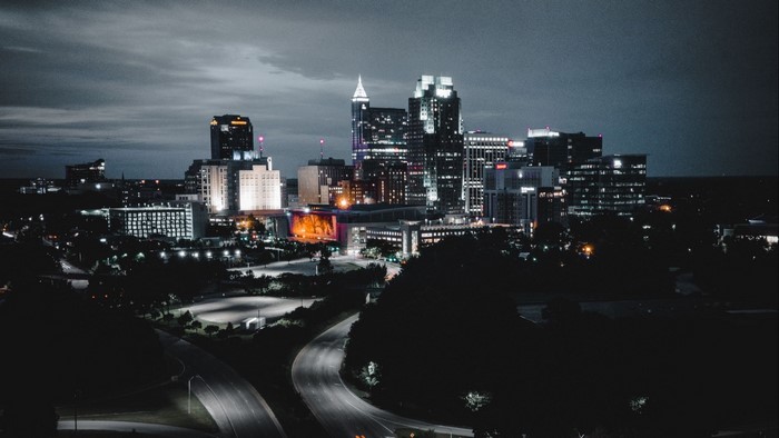 Night city skyline with illuminated buildings and roads