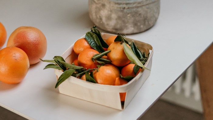 Tangerines in a basket with grapefruits