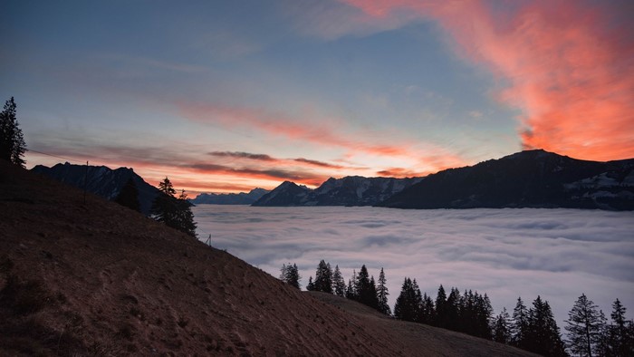 Mountain range above clouds at sunset