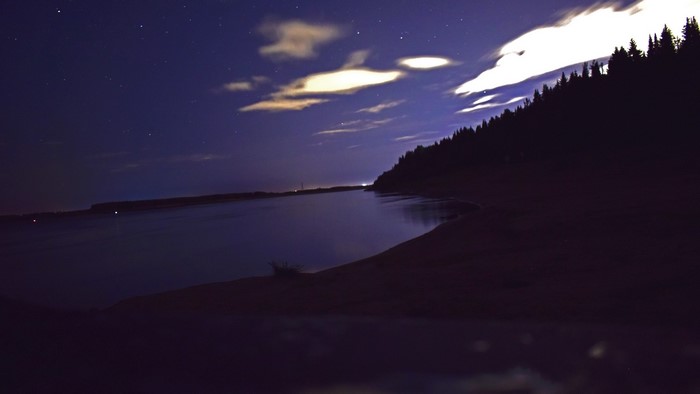 Night sky over a river and forest