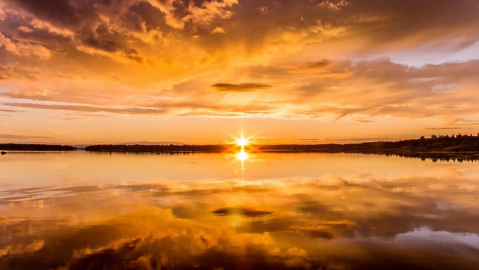 Sunset over a calm lake with dramatic clouds