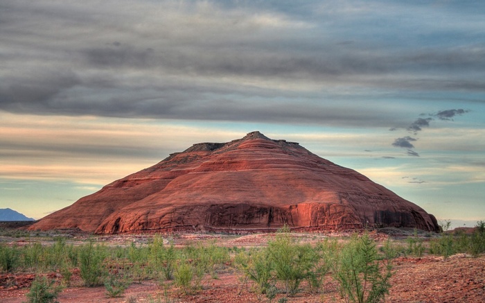 Red rock formation under cloudy sky