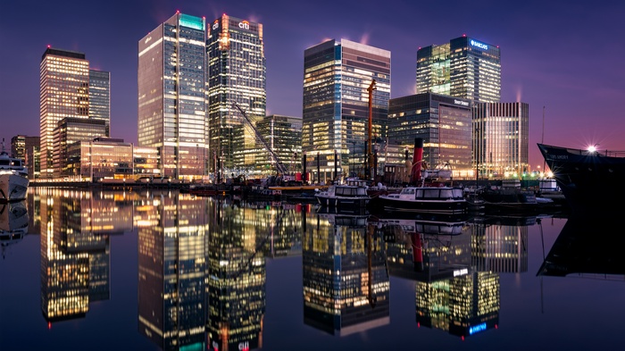 Canary Wharf skyscrapers reflected in water at dusk