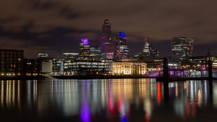 London skyline at night with river reflections