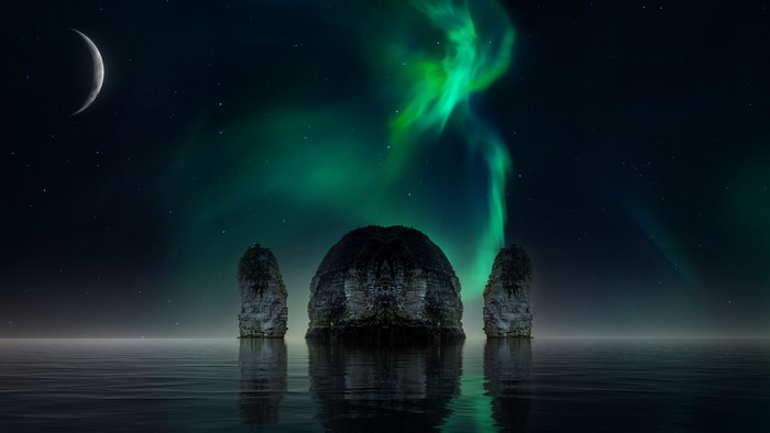Northern Lights over ocean rocks