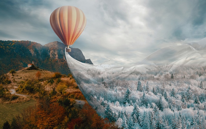 Hot air balloon transitions landscape from autumn to winter