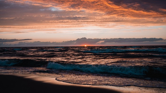Sunset over the ocean with waves