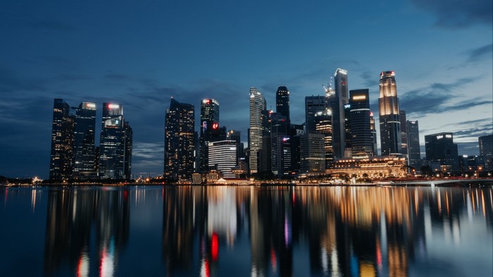 Night city skyline with water reflection