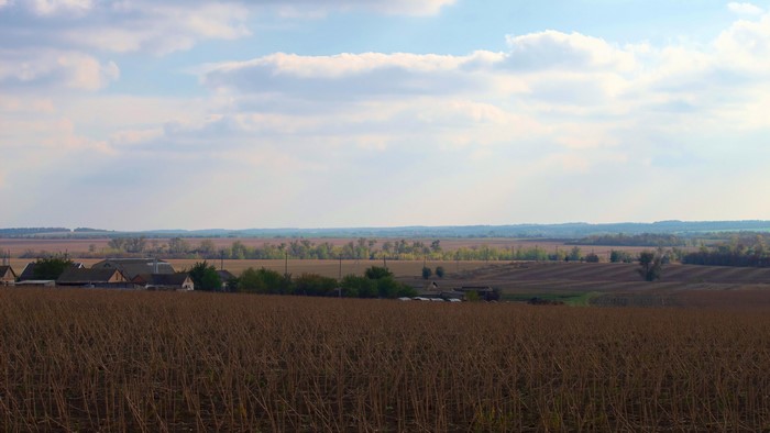 Autumn landscape with harvested fields and village