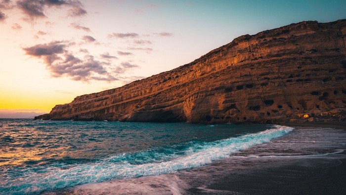 Coastal cliffs and ocean waves at sunset