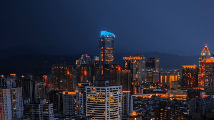 Cityscape at night with illuminated skyscrapers
