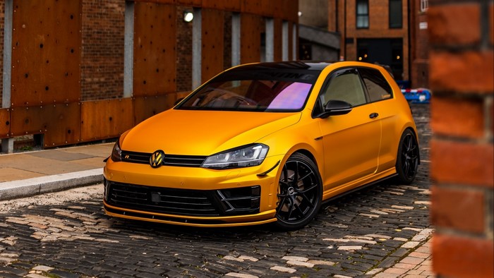 Orange Volkswagen Golf R on Cobblestone Street